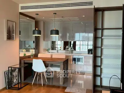 Modern kitchen with dining area featuring sleek cabinetry and stylish pendant lights.