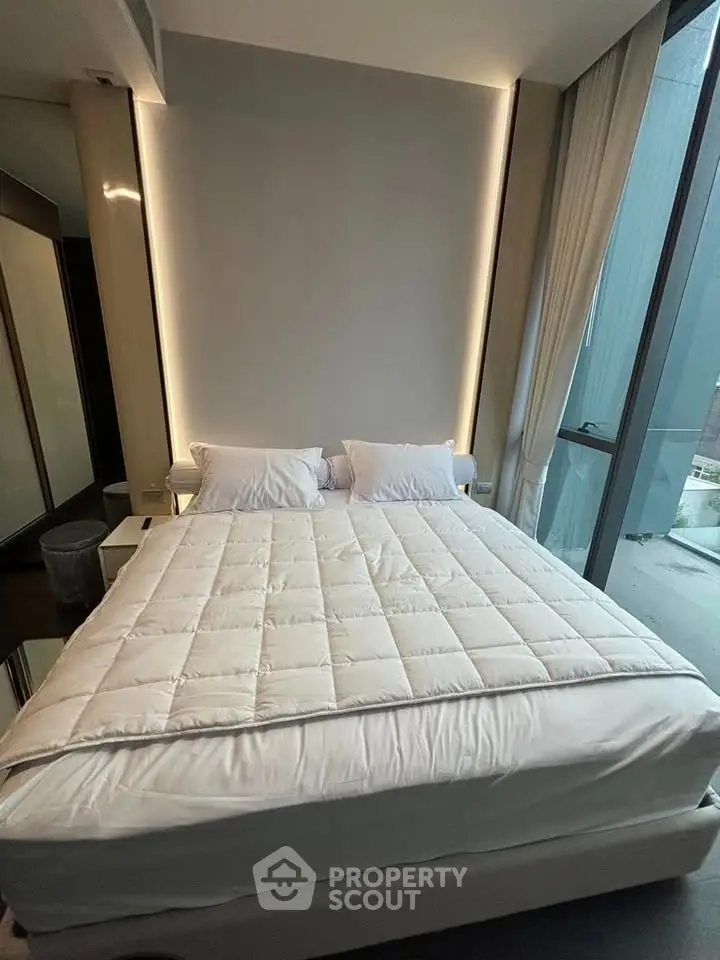 Luxurious bedroom with modern design and floor-to-ceiling windows offering natural light.