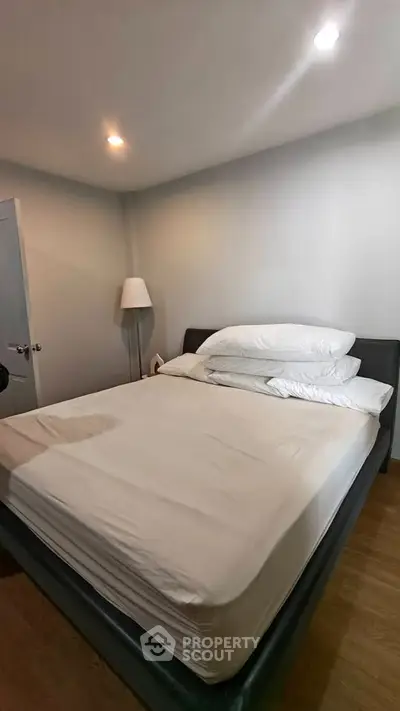 Cozy bedroom with modern lighting and comfortable bed in a minimalist design.