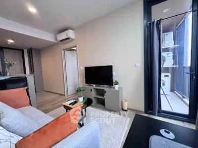Modern living room with balcony and washing machine, featuring cozy seating and stylish decor.