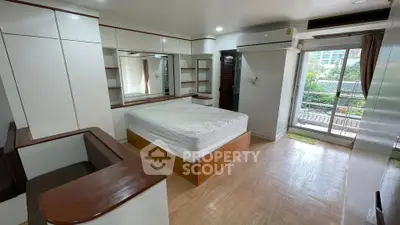 Spacious bedroom with balcony access and modern built-in storage solutions.