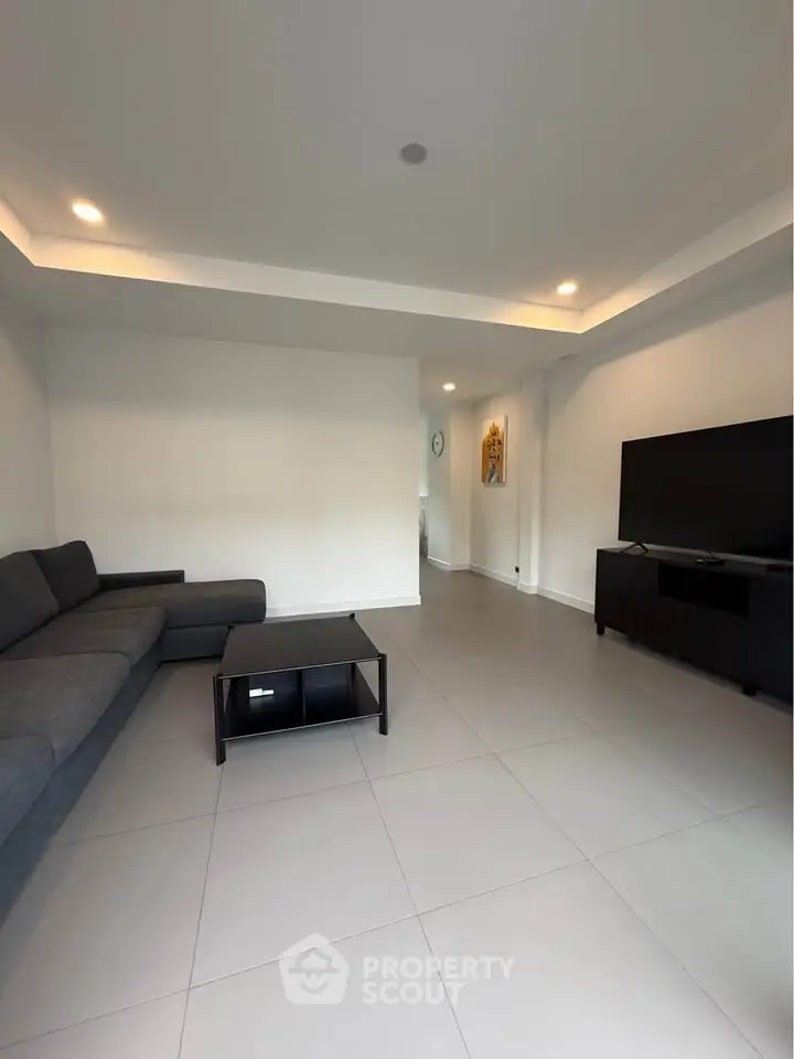 Spacious modern living room with sleek furniture and ambient lighting