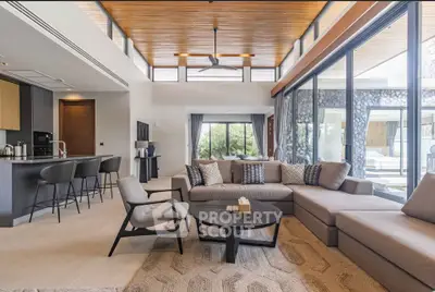 Luxurious open-plan living room with modern furniture and large windows offering garden views.