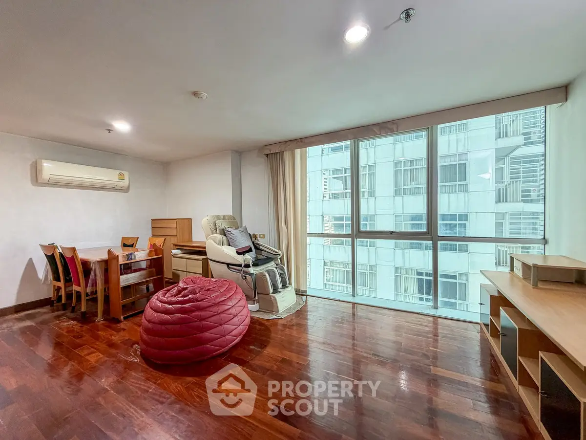 Spacious living room with large windows and hardwood floors in modern apartment
