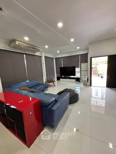 Spacious modern living room with sleek furniture and large windows for natural light.