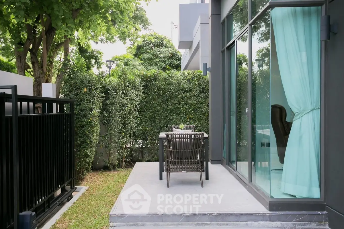 Charming garden patio with modern outdoor seating and lush greenery, perfect for relaxation and entertaining.