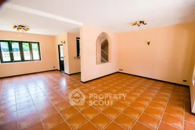 Spacious empty living room with terracotta tiles and large windows