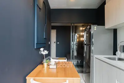 Modern kitchen with sleek design and wooden dining table in stylish apartment.