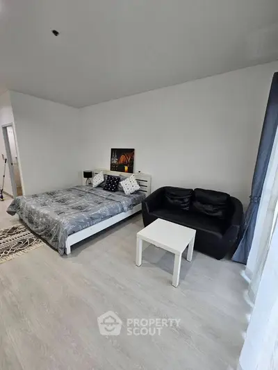 Modern bedroom with stylish decor and cozy seating area, perfect for relaxation and comfort.