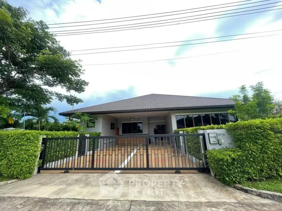 Charming single-story home with gated entrance and lush greenery, perfect for serene living.