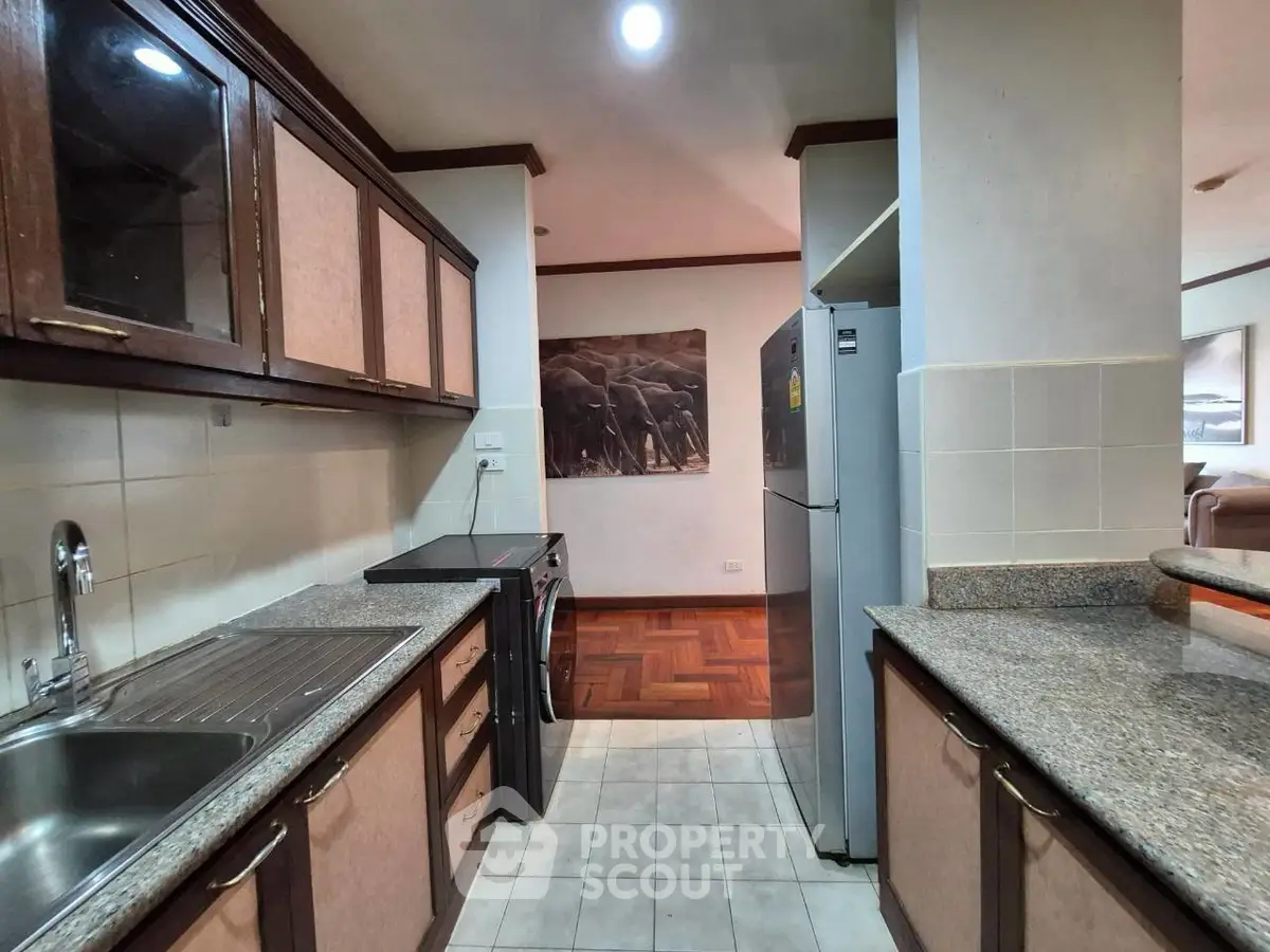 Spacious kitchen with granite countertops and modern appliances in a stylish apartment.