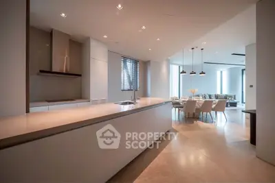 Luxurious open-plan kitchen and dining area with modern design and elegant lighting.