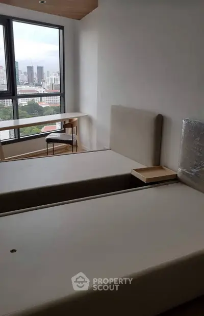 Modern bedroom with city view, featuring twin beds and a minimalist design.