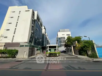 Modern commercial building with sleek glass facade and spacious entrance in urban setting.