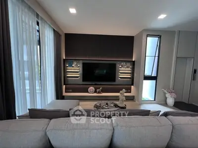 Modern living room with sleek design, large TV, and cozy seating area, perfect for relaxation and entertainment.