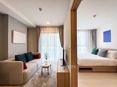 Modern open-plan living room and bedroom with stylish decor and natural light.