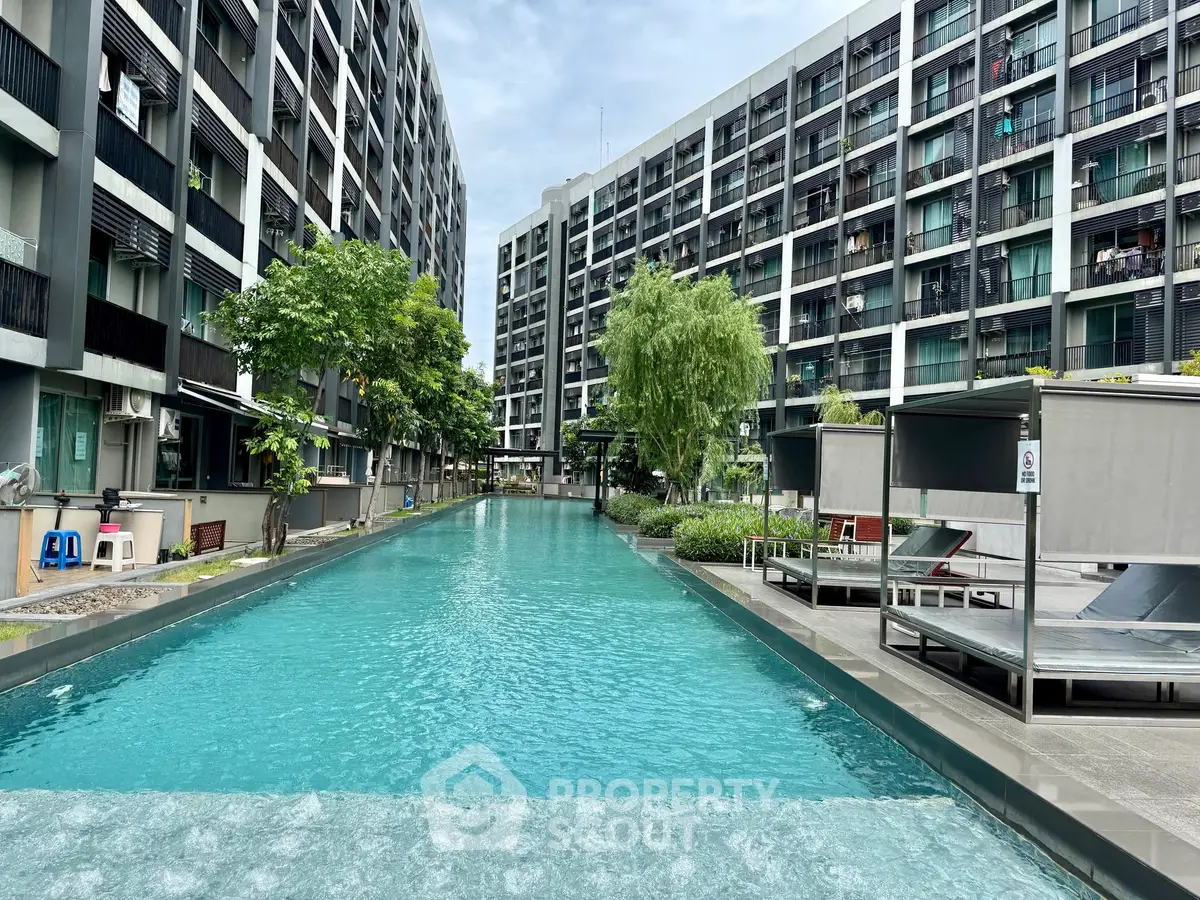 Modern apartment complex with a stunning outdoor pool and lush greenery.