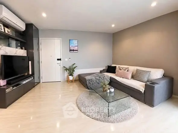 Modern living room with sleek design, featuring a cozy sofa, glass coffee table, and stylish decor.
