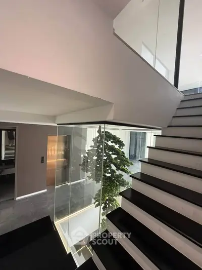 Modern staircase with glass railing and sleek design in luxury home