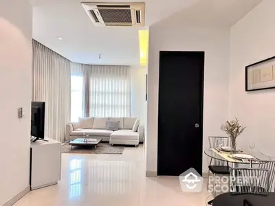 Elegant and modern living room with glossy white floor tiles, plush sofa set, and chic dining area, bathed in natural light from the sheer curtains.