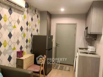 Modern compact kitchen with stylish geometric wallpaper and integrated appliances in cozy apartment.
