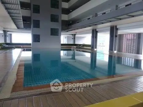 Luxurious indoor swimming pool in modern residential building with sleek design and ample natural light.
