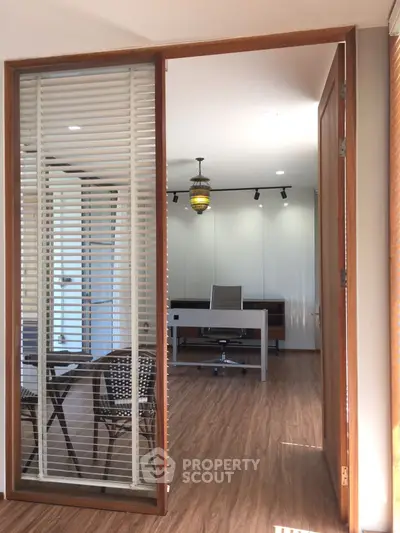 Modern study room with sleek desk and chair, wooden flooring, and stylish lighting.