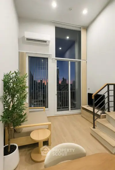 Modern living room with high ceiling and city view balcony at sunset