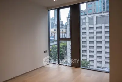 Spacious empty room with large windows offering a city view, perfect for customization.
