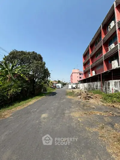 Scenic view of residential building exterior with lush greenery and clear blue sky.