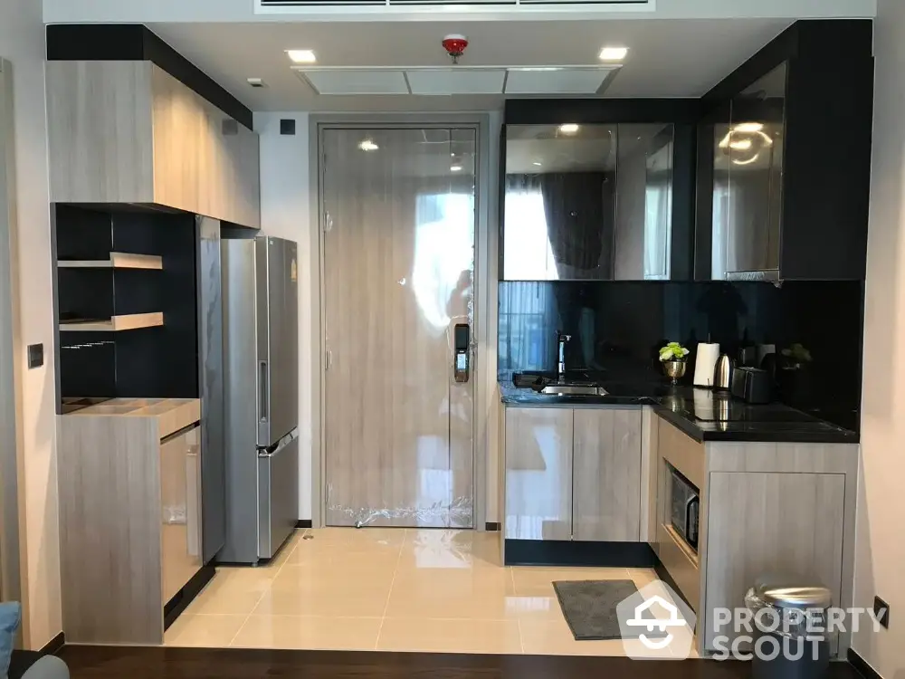 Modern kitchen with sleek cabinetry and stainless steel appliances in a contemporary apartment.