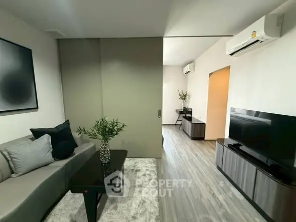 Modern living room with sleek furniture and air conditioning, featuring a stylish open layout and elegant decor.
