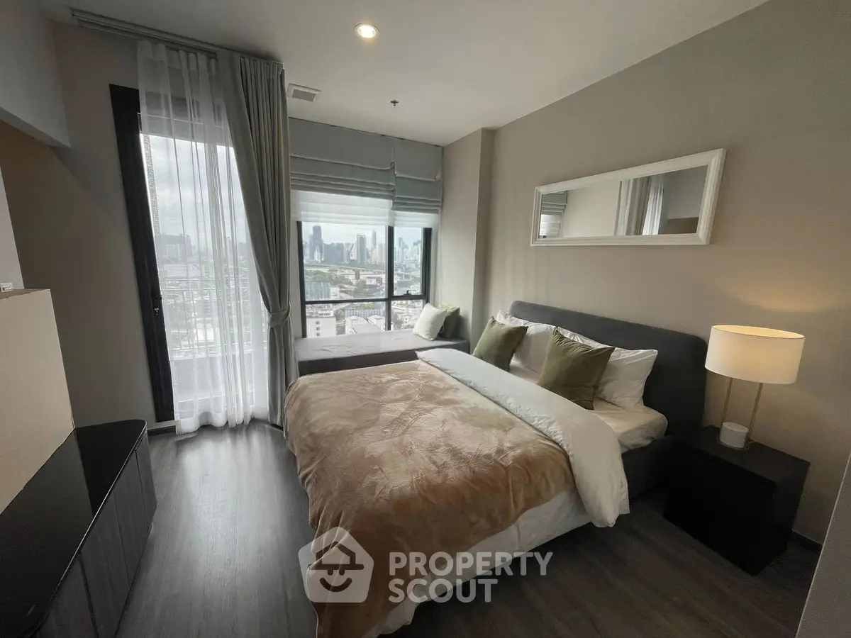 Modern bedroom with city view, featuring a cozy bed, stylish decor, and large windows for natural light.