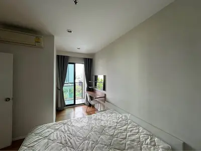 Modern bedroom with balcony view and study desk, ideal for urban living.