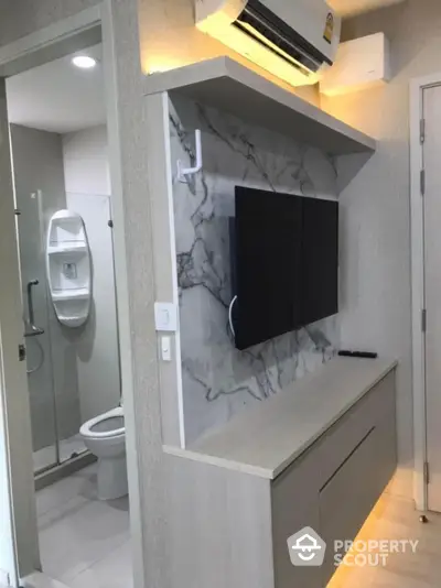 Modern apartment interior with wall-mounted TV and air conditioning near bathroom