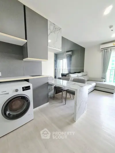 Modern living room with sleek kitchen and washing machine in stylish apartment