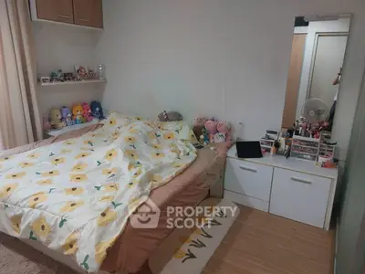 Cozy bedroom with floral bedding and plush toys, perfect for a comfortable living space.