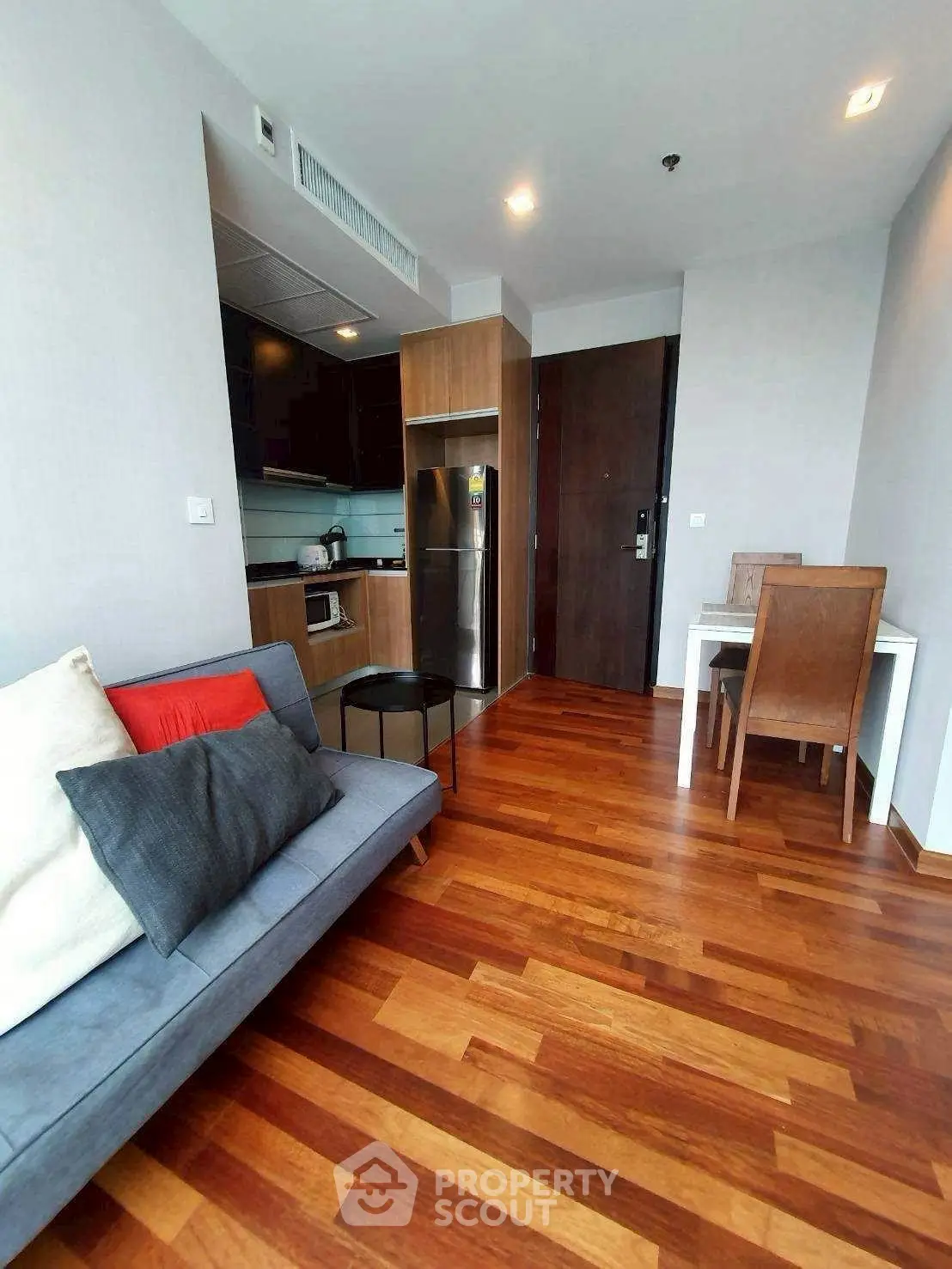 Modern apartment interior with wooden flooring and compact kitchen