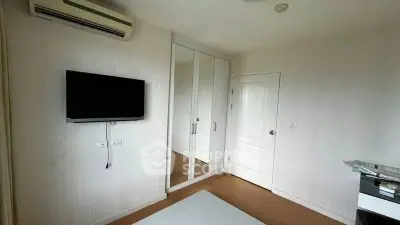 Modern bedroom with mirrored closet and wall-mounted TV
