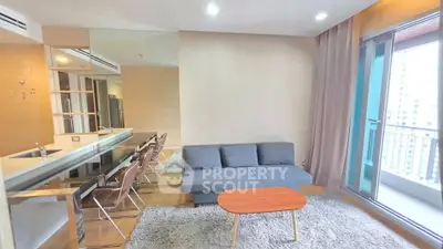 Modern living room with sleek furniture and balcony access in a high-rise apartment.