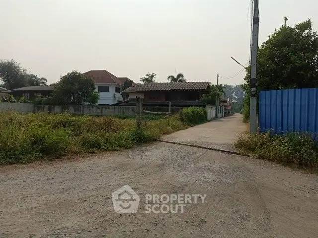 Charming suburban property with spacious yard and rustic driveway, ideal for serene living.