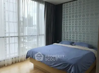 Modern bedroom with large windows and stylish decor in urban apartment