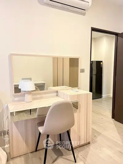 Modern bedroom with stylish vanity and chair, featuring sleek design and neutral tones.