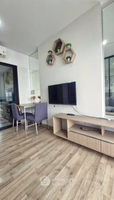 Modern living room with stylish decor and wall-mounted TV in a cozy apartment setting.