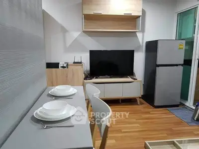 Modern living room with dining area and sleek appliances in a cozy apartment setting.