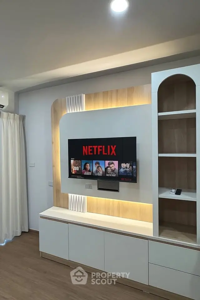 Modern living room with built-in TV unit and ambient lighting, perfect for entertainment.