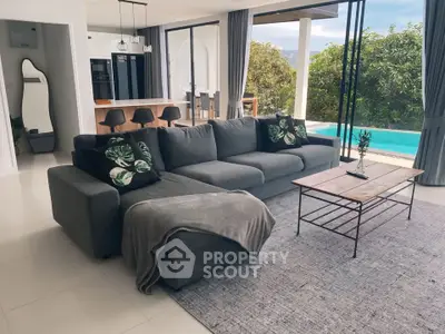 Luxurious open-plan living room with pool view and modern furnishings