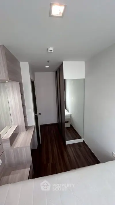 Modern bedroom with sleek wooden flooring and built-in storage solutions