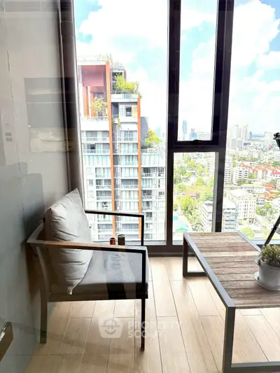 Modern balcony with city view, stylish seating, and wooden flooring in urban high-rise apartment.