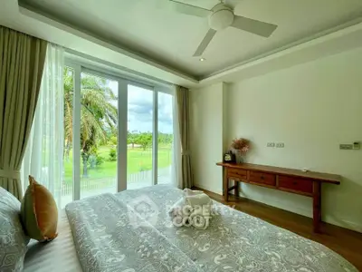 Spacious bedroom with large windows offering lush garden views and elegant decor.